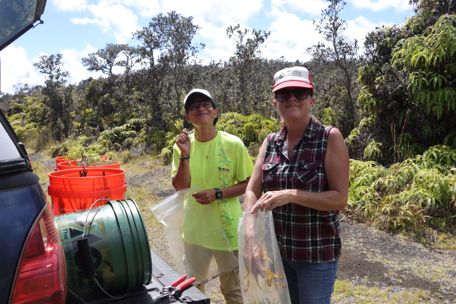 Darcy and Molly behind the Tacoma truck with buckets on the tailgate and foliage in our hands.