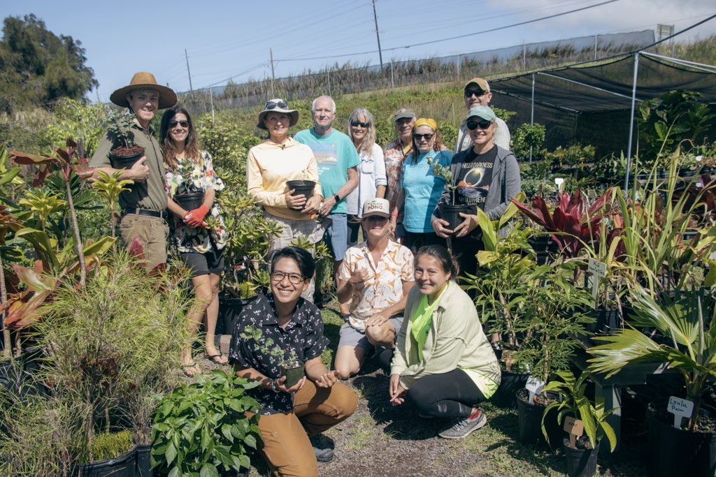 Group of participants from native planting workshop at Elemental Plants. Everyone holding their new plant keiki right in the middle of the native plant section of the nursery.